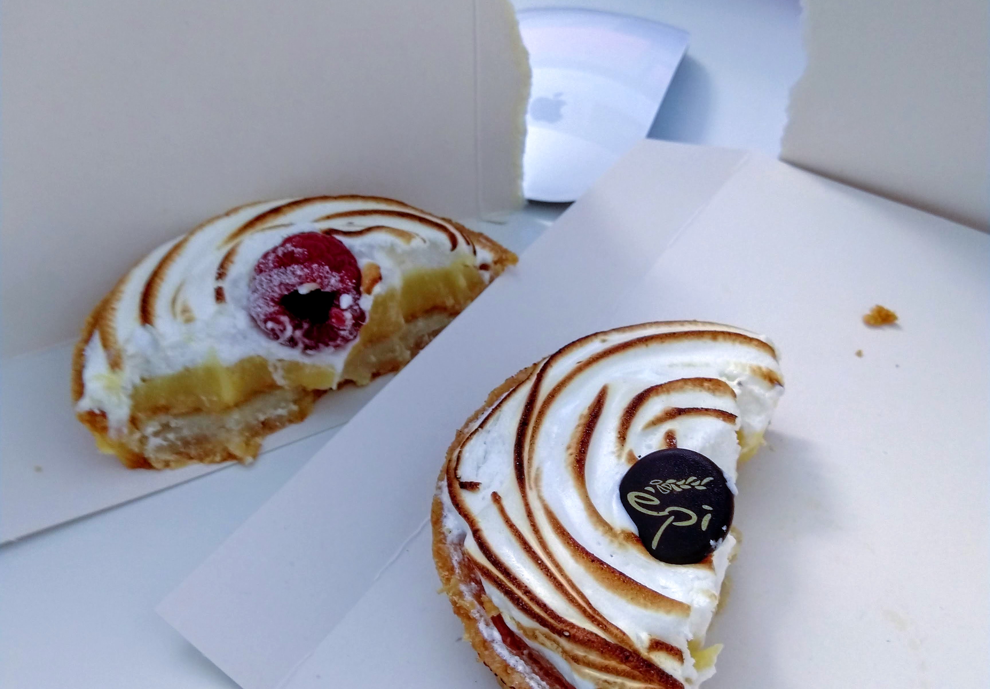 A meringue tartelette divided in two parts at a desk